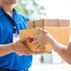 Woman hand accepting a delivery of boxes from deliveryman
